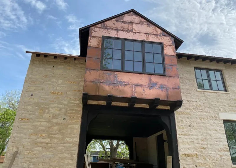 Copper metal panel facade on a stone building for Skylight Installation in Brecknock