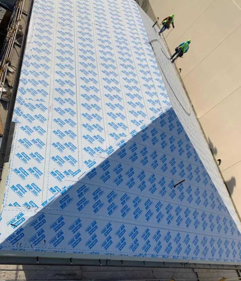 Professional roofers installing underlayment on a metal roof in Brecknock